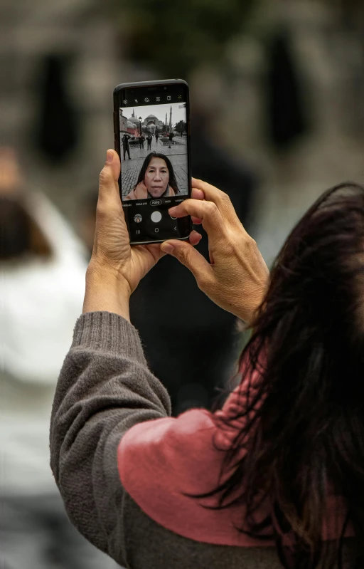 woman holding up her phone taking a selfie