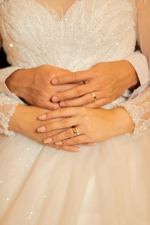 a bride and groom's hands holding each other