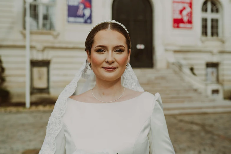 a bride dressed in white stands outside the church