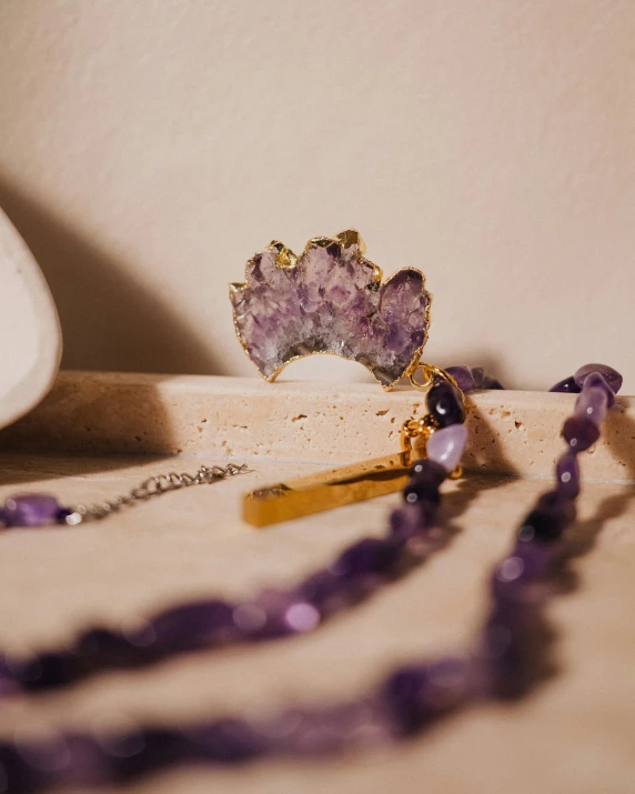 a gold necklace and some jewelry are laying on a table