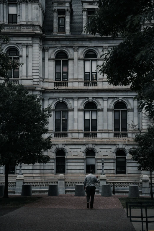 an old building with a person walking next to it