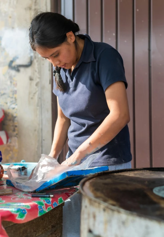 a woman is washing dishes and a pink and green table