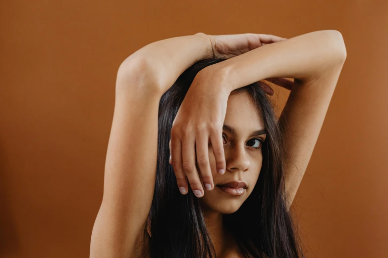 a woman is holding her hair up with one hand