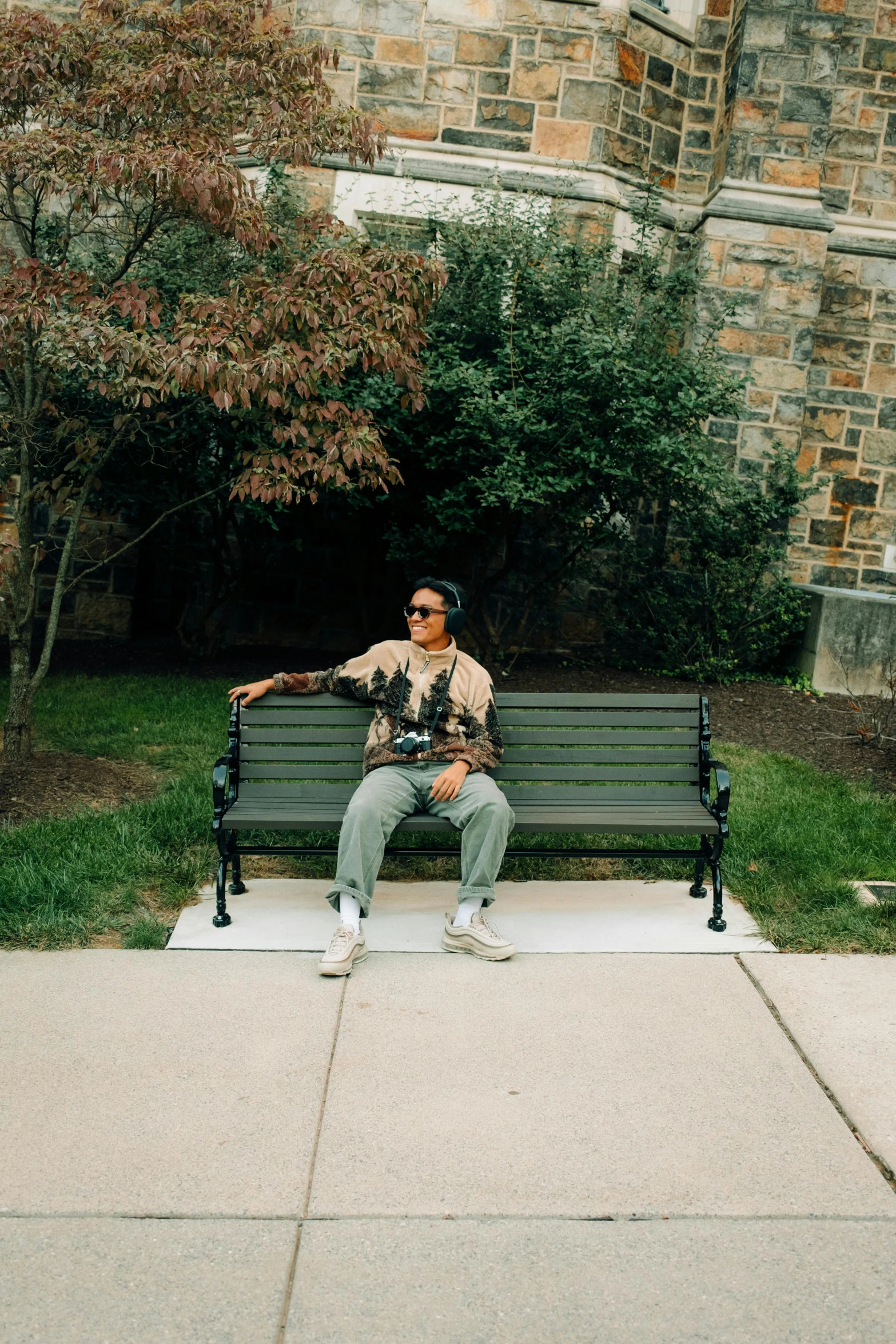 man sitting on a park bench with a camera