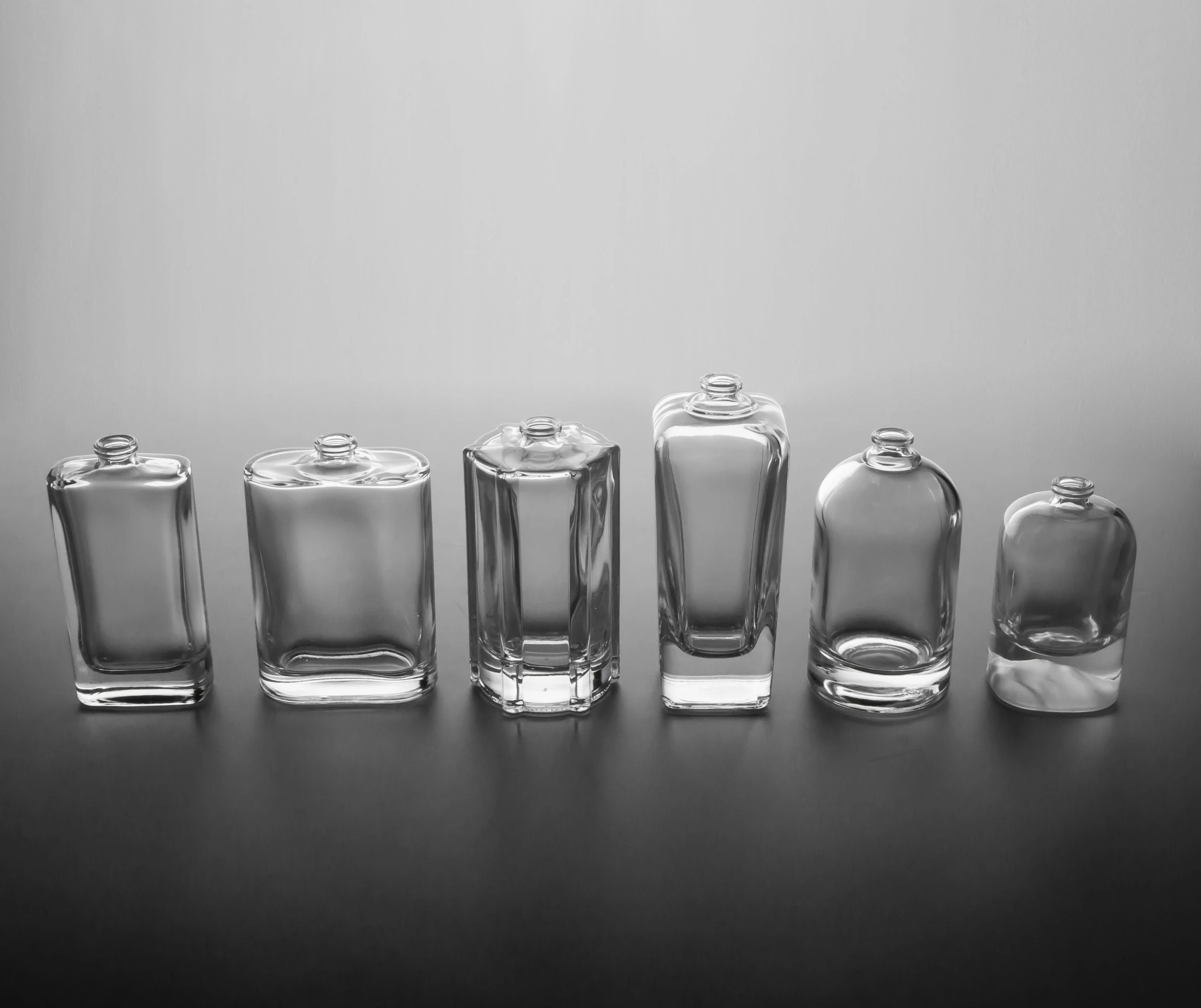 several glass containers lined up on a black table