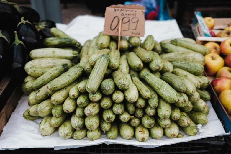 cucumbers, apples and other fruits on display at a market