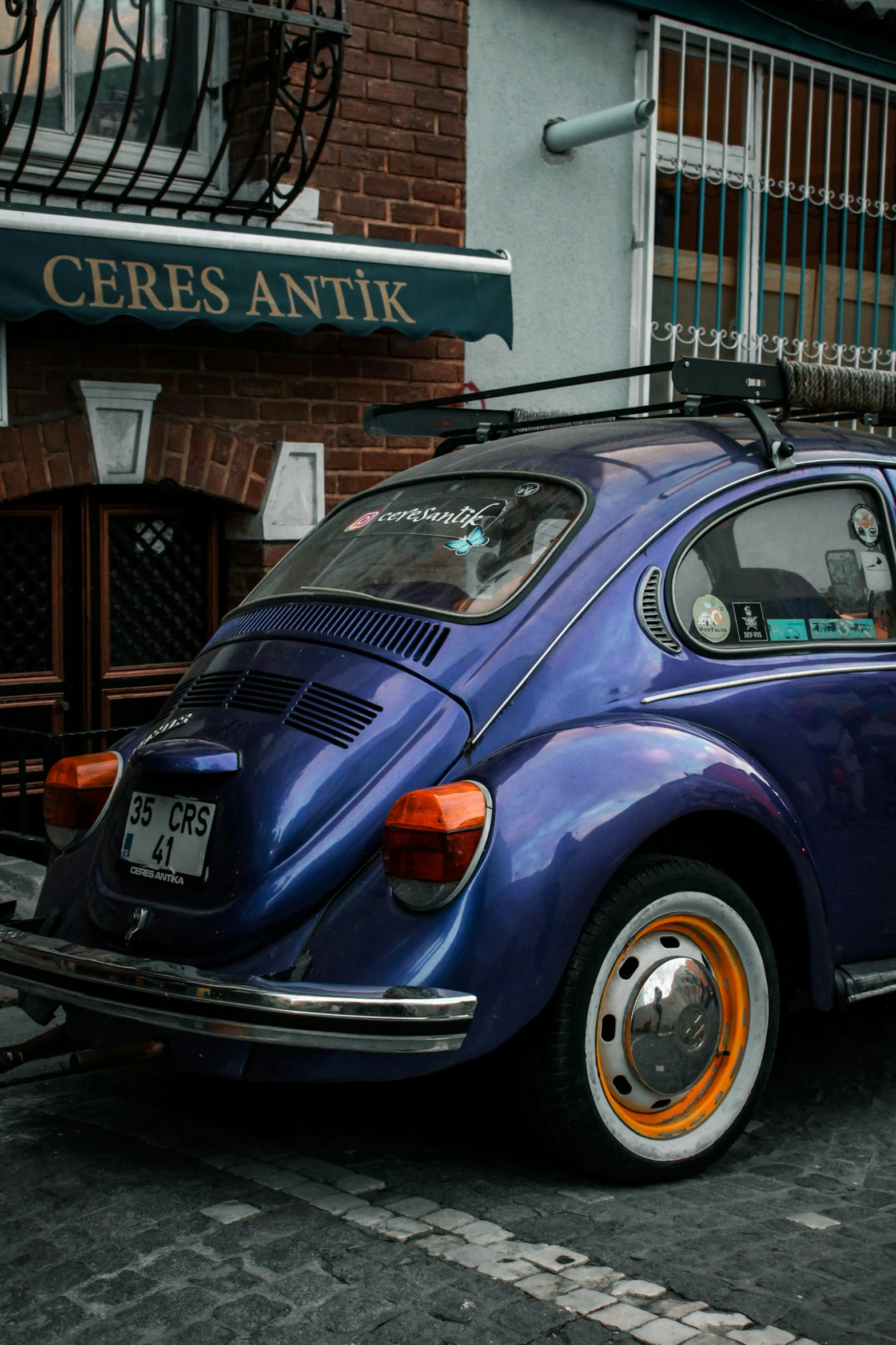 an old purple volkswagen beetle parked on the side of a street