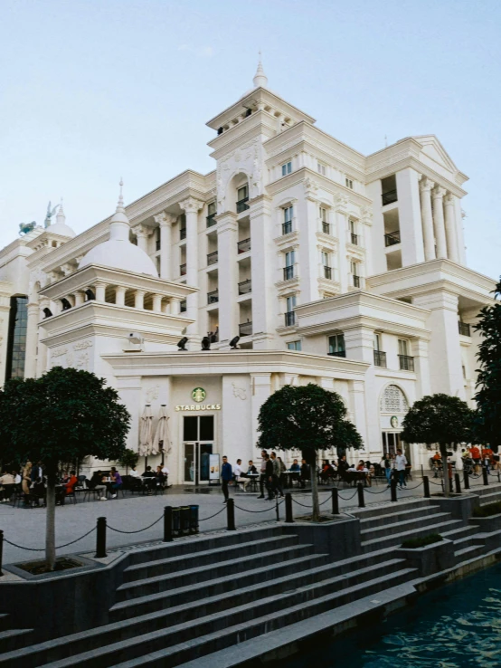 several people in front of a white building with stairs