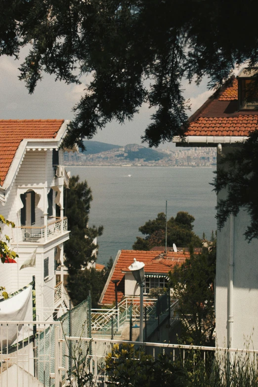 two white buildings with red roof tops near water