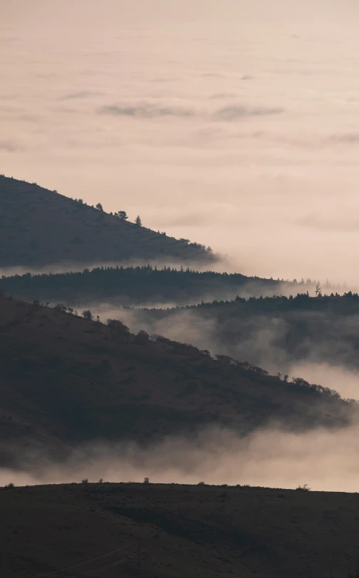 there is a mountain in the distance with fog around it