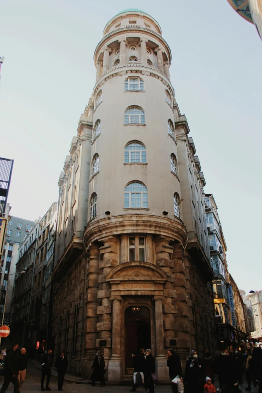 a building with several people walking and a bus going by