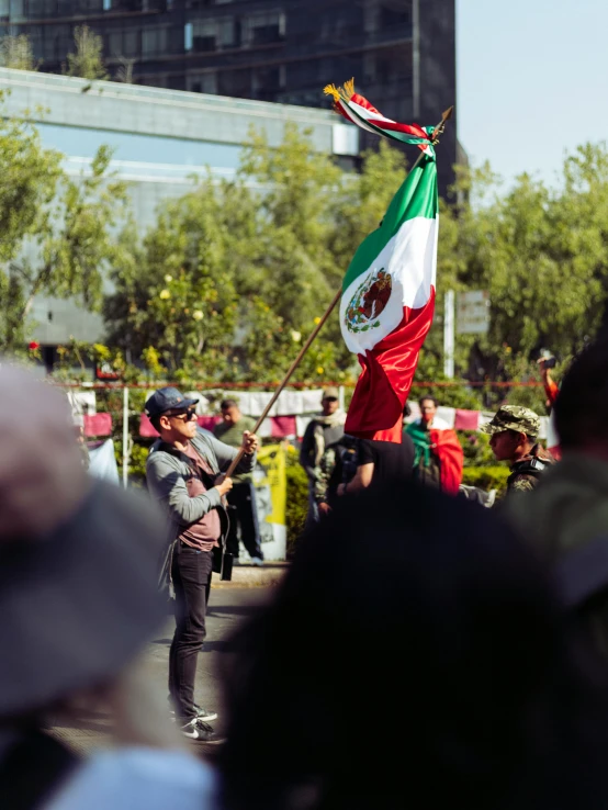 a group of people marching with mexican flags and confetti