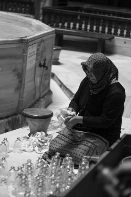 a woman sitting in front of a table filled with wine glasses