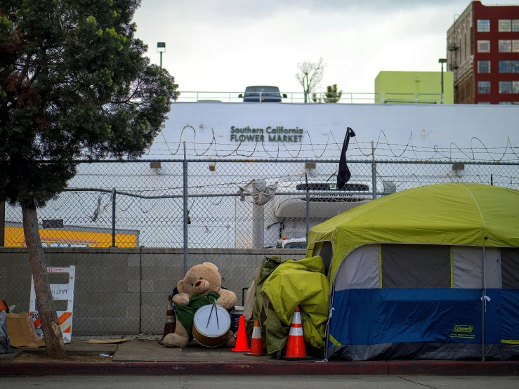 two teddy bears are next to some tents and cones