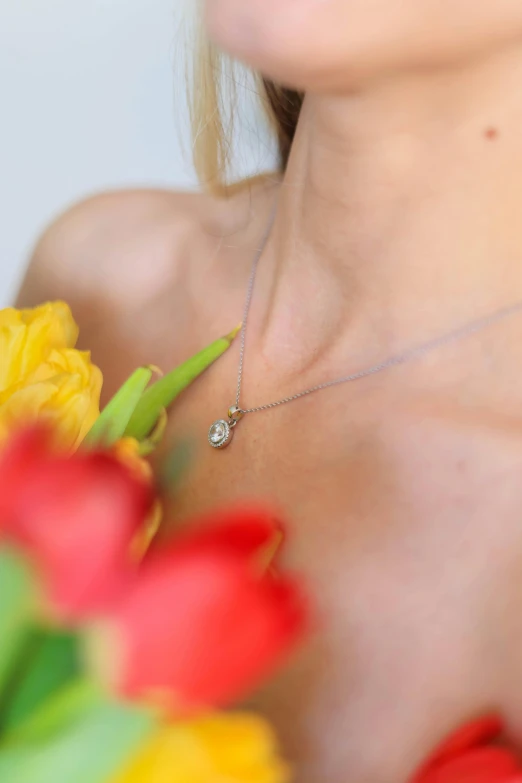 a girl with flowers in her back and a necklace on