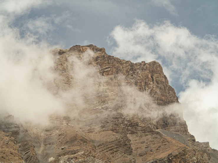 clouds over a high rock formation near a mountain