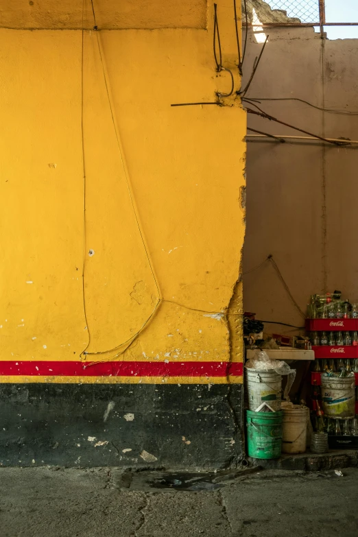 a yellow wall with some cans and cans in front