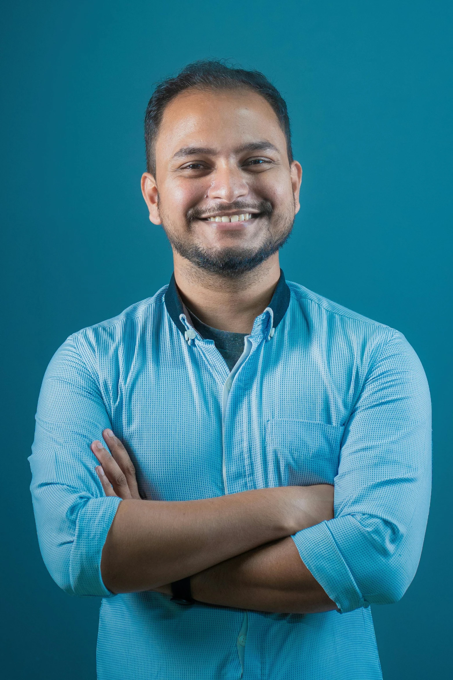 a man posing for the camera with his arms folded and eyes closed