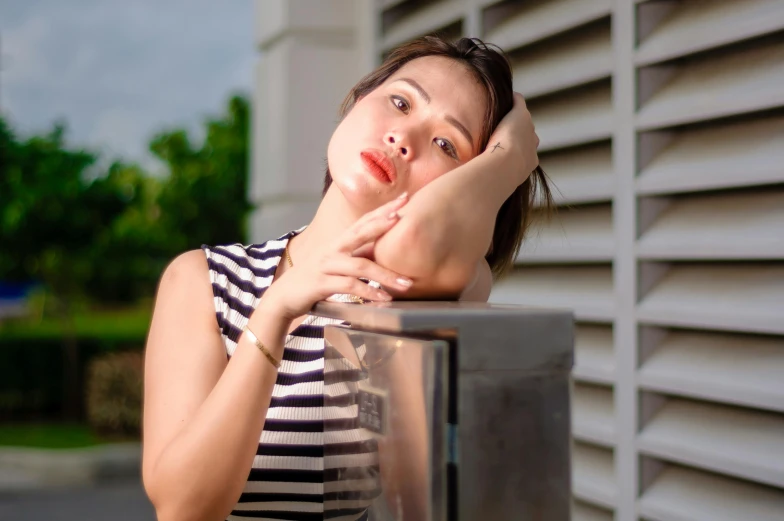 a woman leaning on a bench in a striped shirt