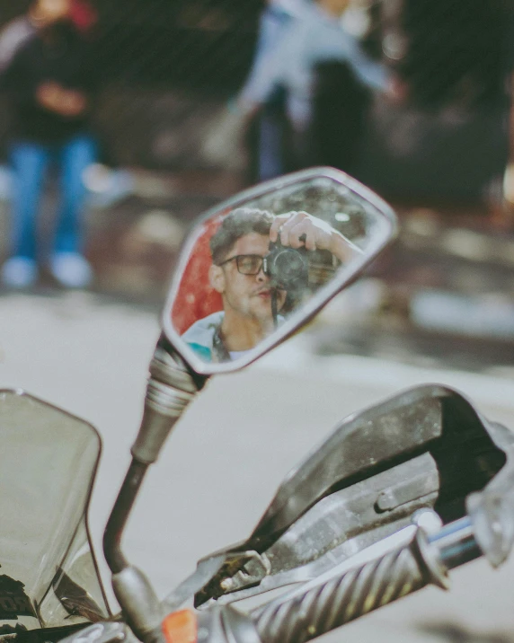 the man is looking in a mirror on his motorcycle