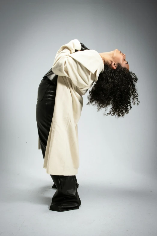 a man is wearing a white coat and standing on his head