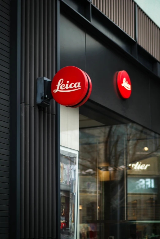 red sign mounted on side of building saying leica