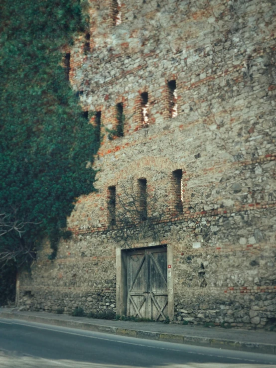 a stone building with two wooden doors on the side