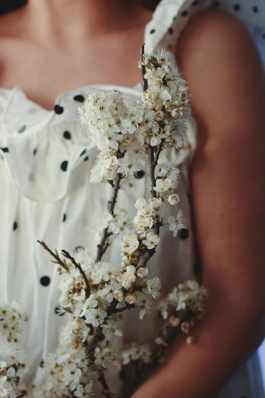 a woman wearing a dress with dots and flowers