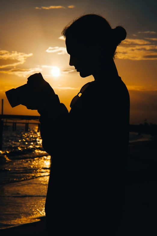 a person standing on a beach with a cell phone