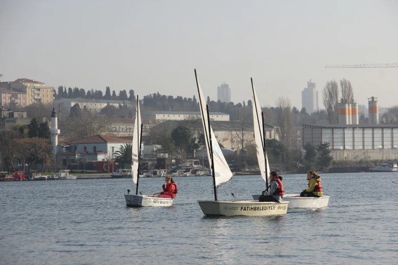 some people in small sail boats on a body of water