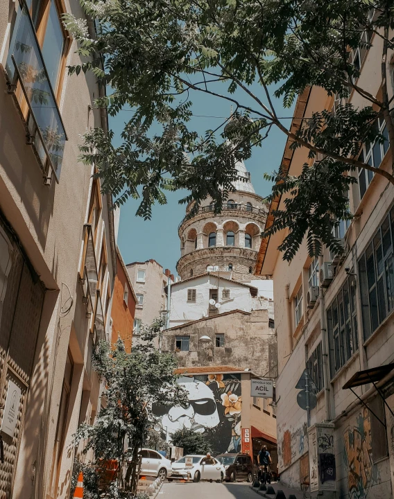 a narrow street with old buildings and a tower in the background