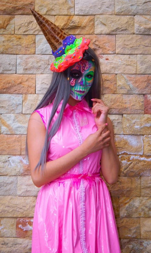 a woman with dark hair wearing a pink costume and a unicorn hat