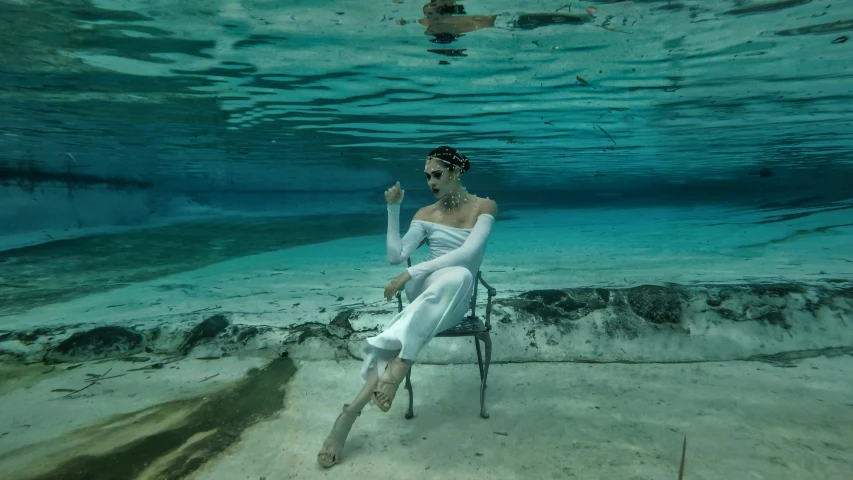 a girl that is sitting down in the ocean