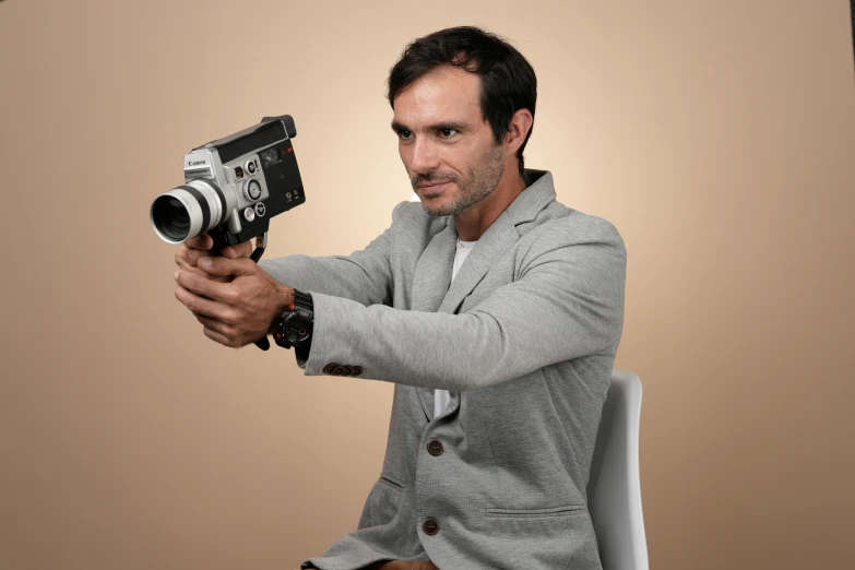 a man sitting down with a camera in his hand
