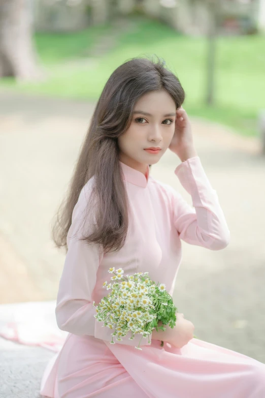 a woman in a pink dress sitting with flowers