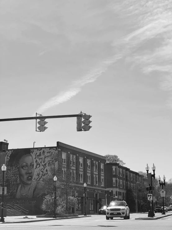 a car drives past a street light that has an image on it