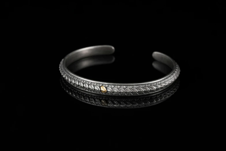 a silver cuff with a white diamond in the middle