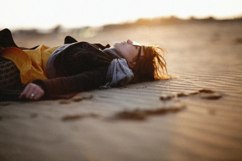 a woman laying on the beach on her stomach