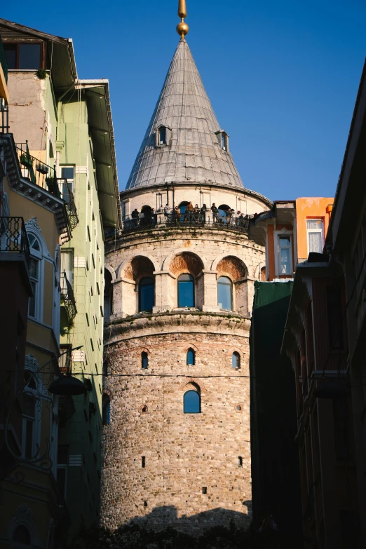 the top of a tower stands between two buildings