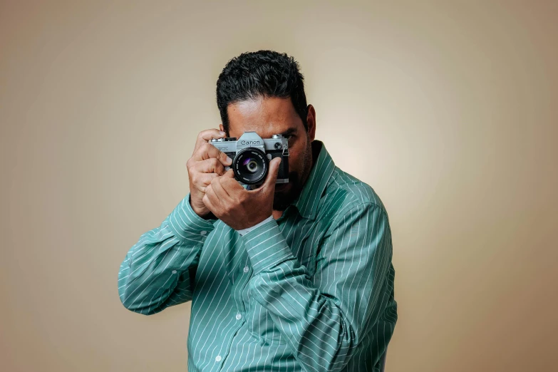 a man holds a camera over his eye