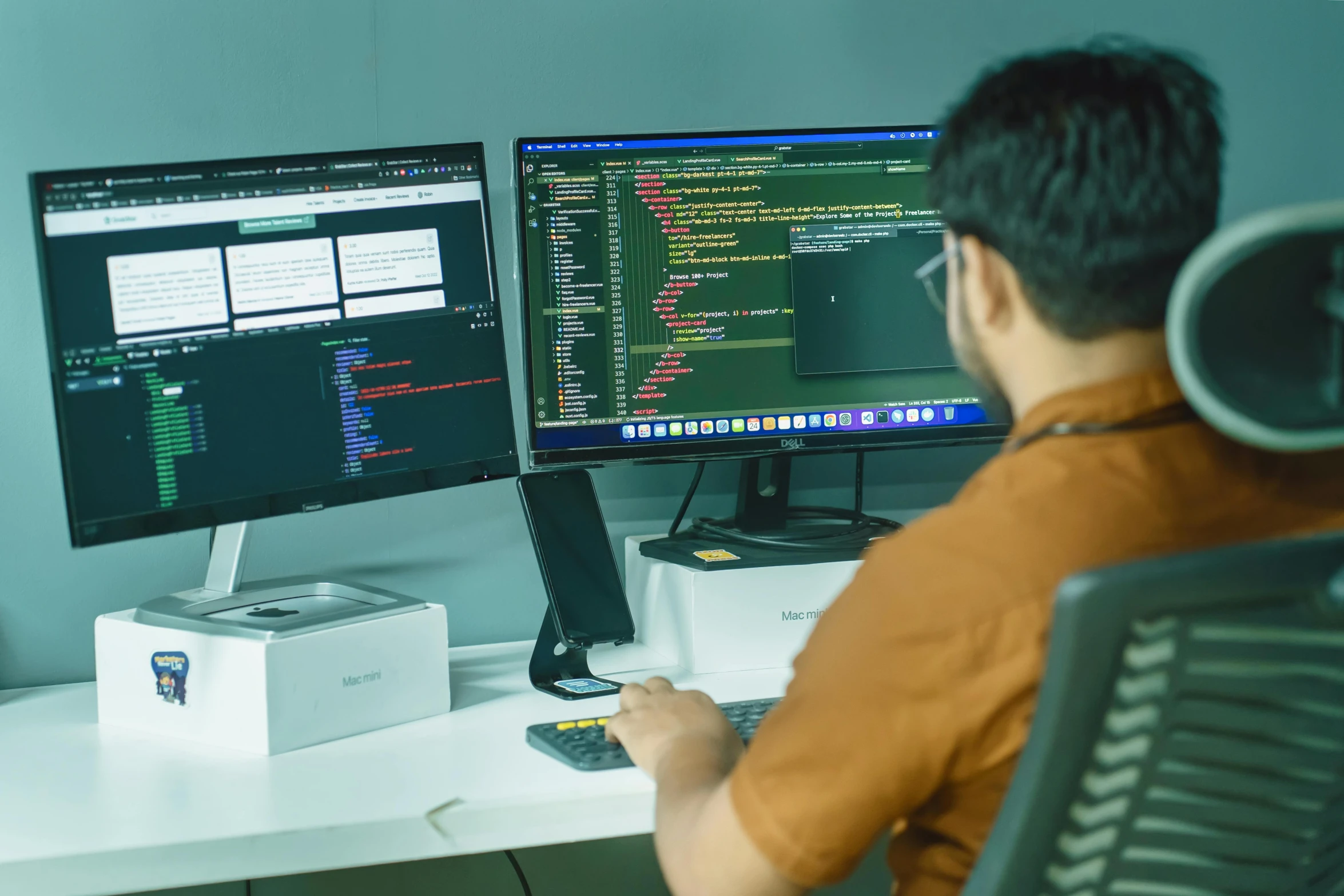 man sitting at desk using computer with multiple computer monitors on