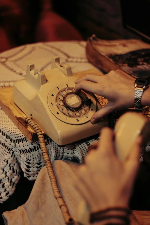 a person typing on an old fashioned telephone