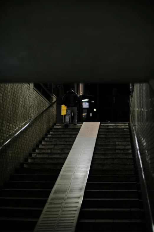 a person walking up stairs at night under an umbrella