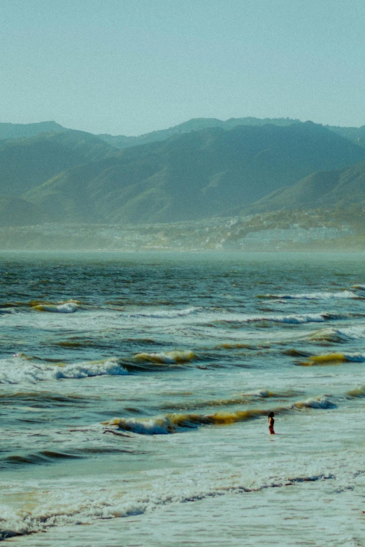 two people are walking out to the ocean