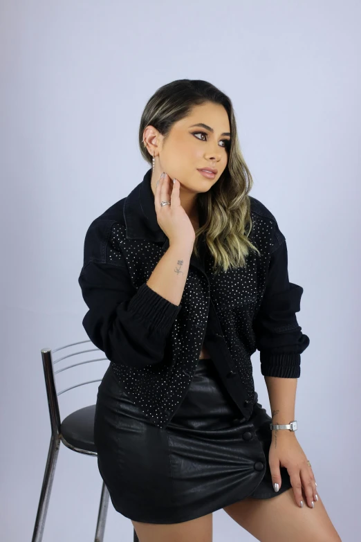 a woman sitting on a chair wearing a black top