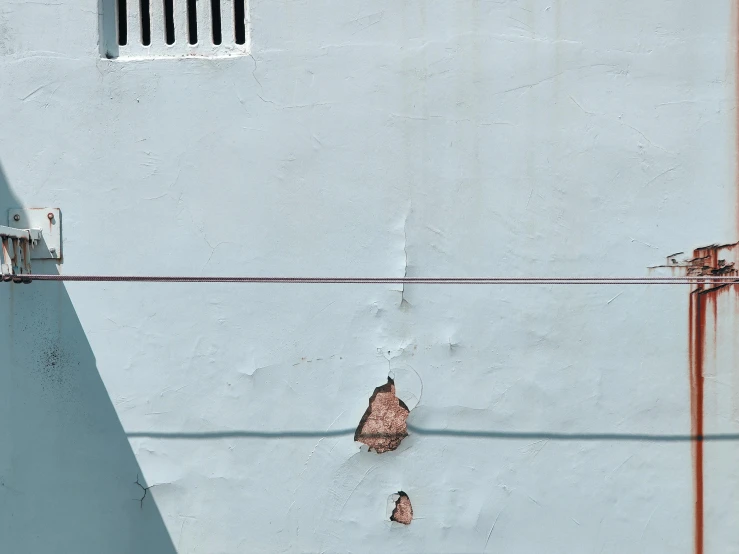 a close up of the corner of a building, with wire attached