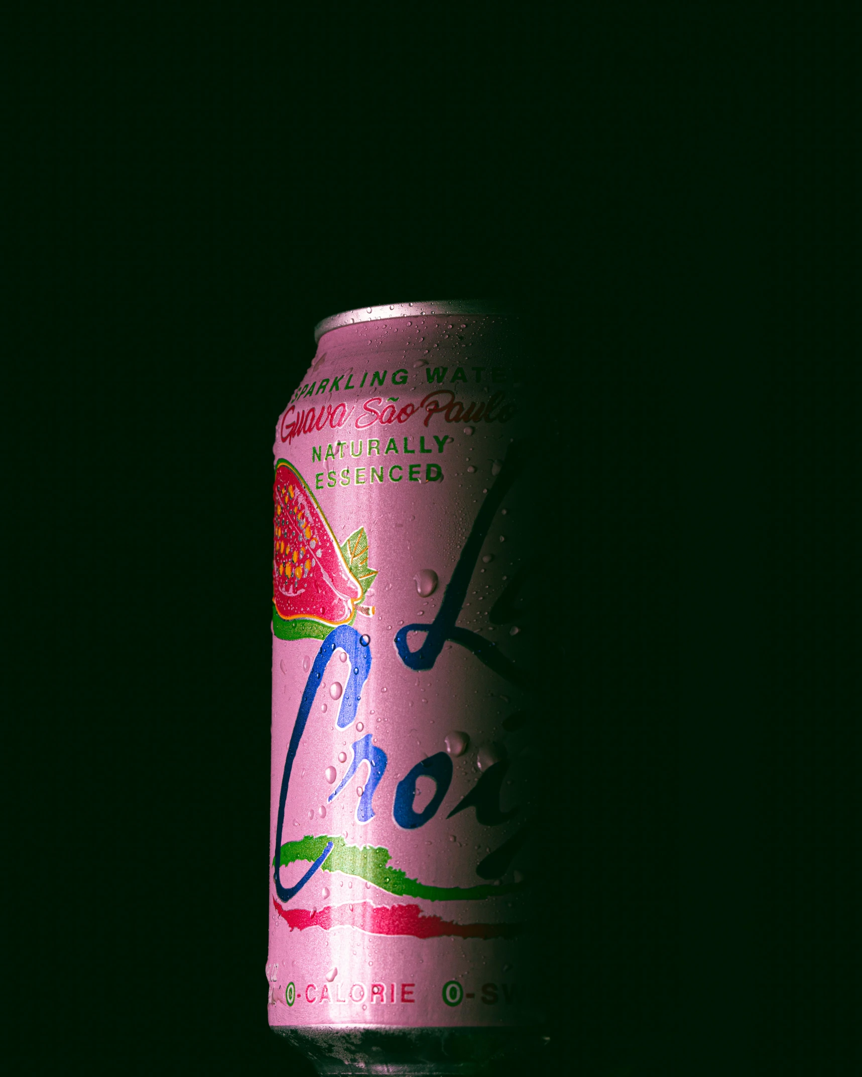 a pink soda can on top of a black table