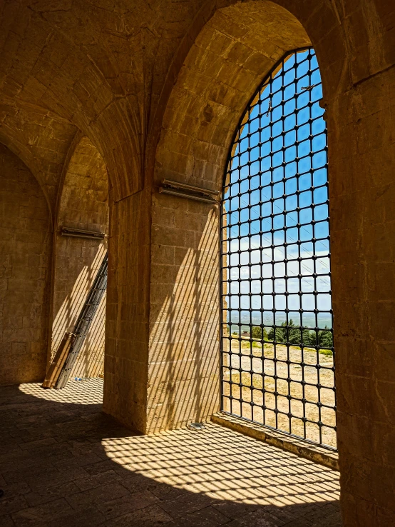 the view from within an arched passageway in a stone building