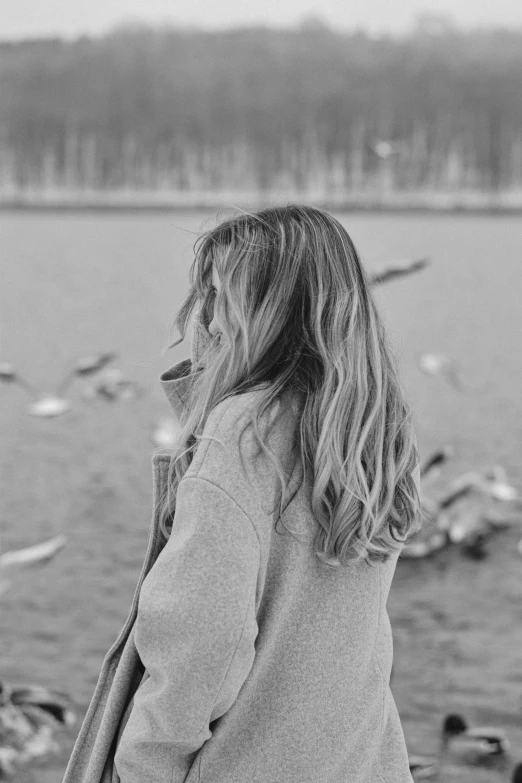 a woman staring into the distance at a body of water