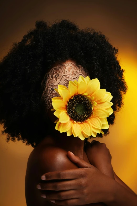 a person with afro hair wearing a sunflower